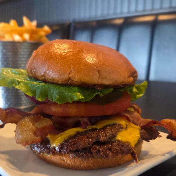 Pub 47's double cheeseburger with bacon, lettuce, tomato, and a side of waffle fries.