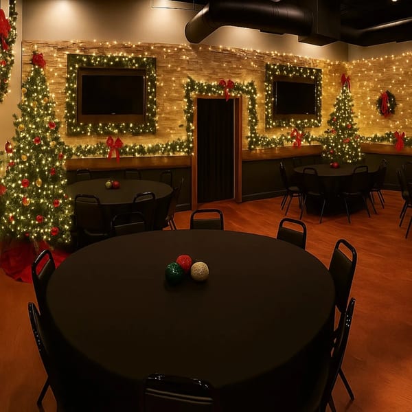 Pub 47 dining room decorated for Christmas with lit trees, garlands, and round tables.